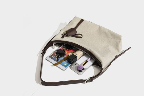 Lässige Hobo-Schultertasche aus haferfarbenem Canvas mit dunkelbraunen Besätzen in Lederoptik, silberfarbenem Reißverschluss und langem, verstellbarem