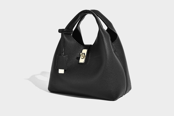 Structured pebbled-texture bucket bag with arched top handles, gold-tone turn-lock closure, and detachable shoulder strap