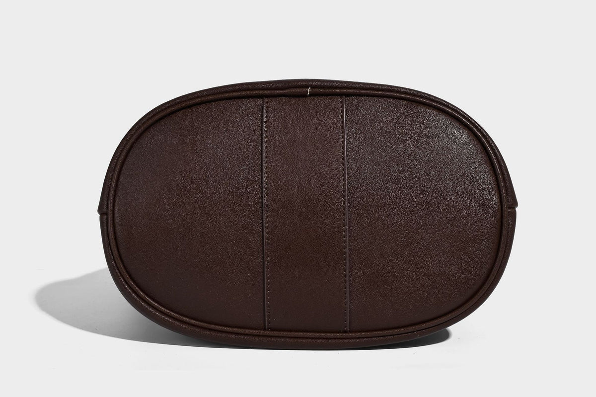 Slouchy bucket hobo shoulder bag in dark brown with glossy leather-look finish, top zip closure, and long adjustable, detail