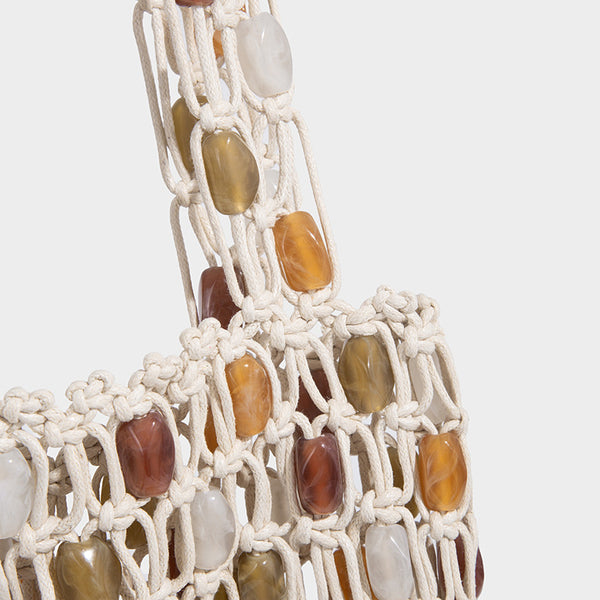 Cream macramé open-weave tote bag with multicolor amber olive and translucent bead accents and woven shoulder straps, detail