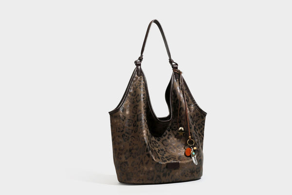 Large slouchy leopard-print shoulder tote bag with glossy tan-and-brown finish, dark brown leather-look trim, single