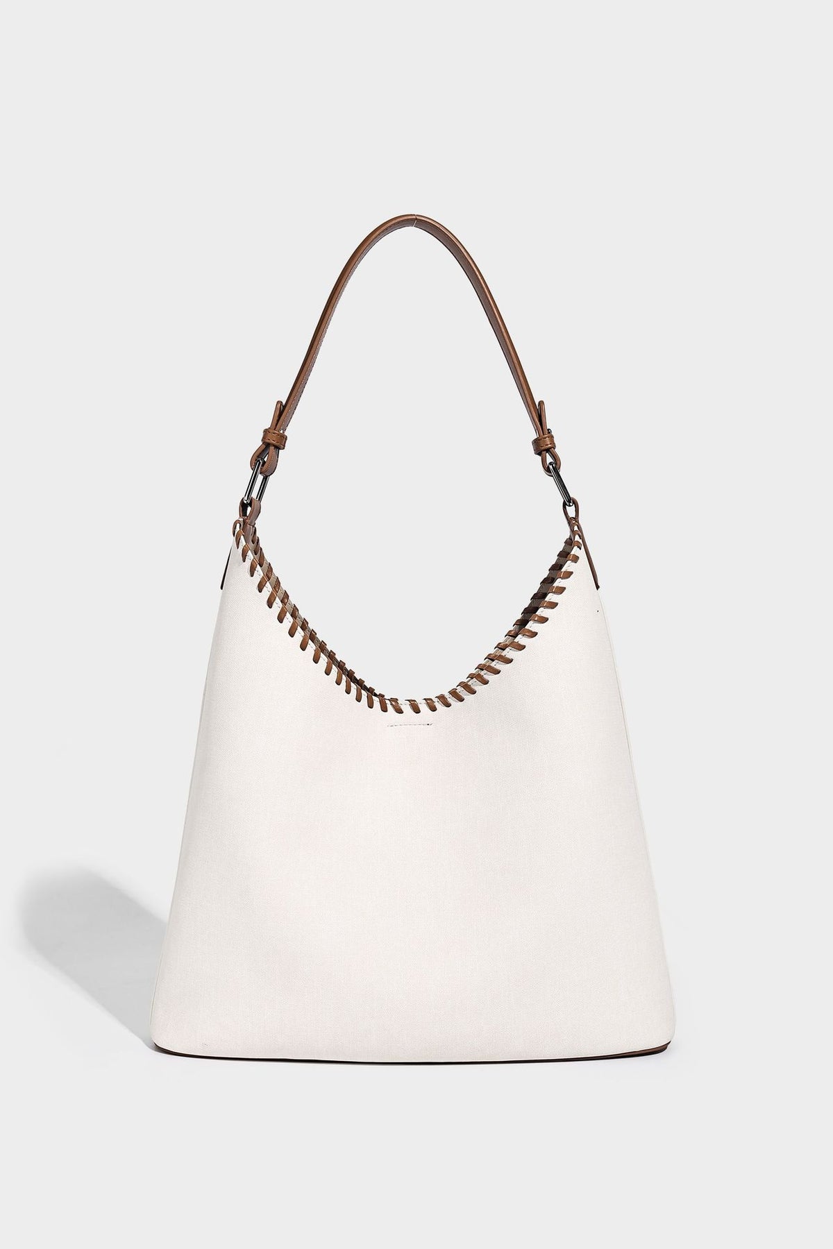 Denim-blue hobo tote with white leather-look shoulder strap, contrast whipstitch trim along curved open top, and silver-tone