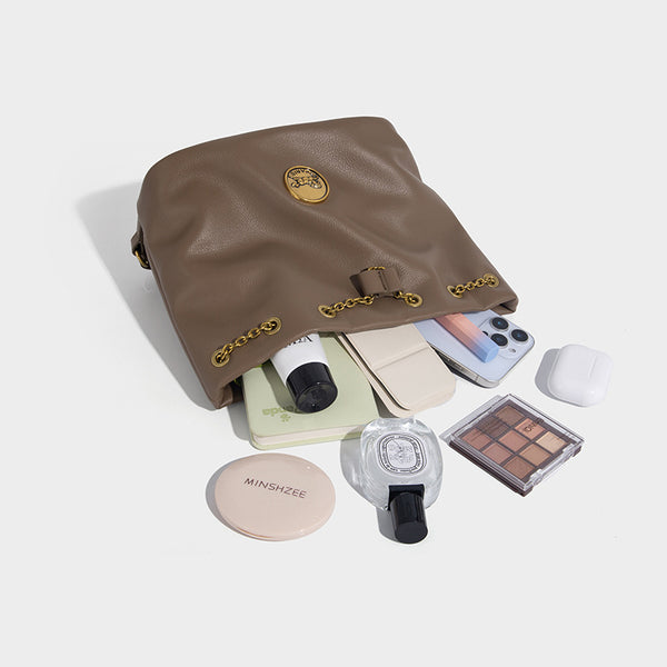 Kleine Bucket-Tasche aus genarbter Lederoptik mit goldfarbenem Ringhenkel, Kettenmedaillon als Akzent und verstellbarem Rucksack