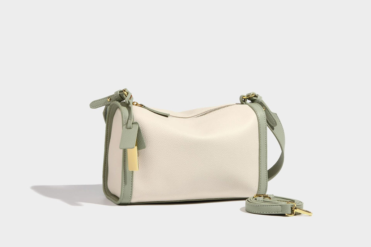 Structured two-tone shoulder bag with pebbled leather-look finish, contrast trim, top zip closure, and gold-tone hardware