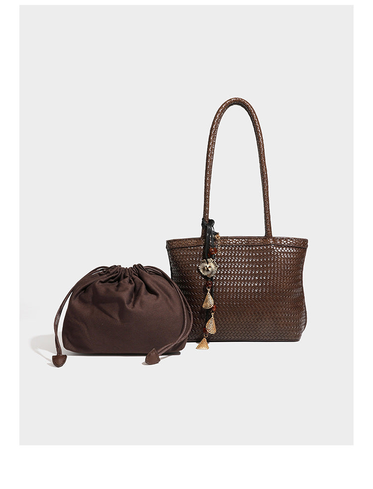 Structured woven leather-look tote bag in dark brown with long shoulder straps, side drawstring ties, and gold filigree