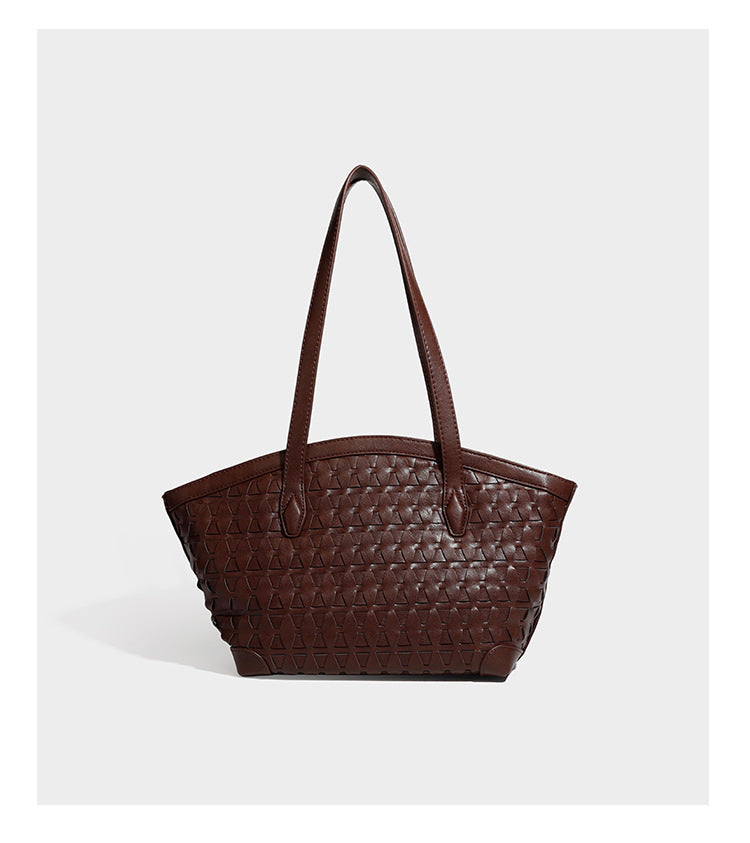 Large leather-look tote bag with geometric woven emboss, double shoulder straps, and round woven cord charm in brown, detail