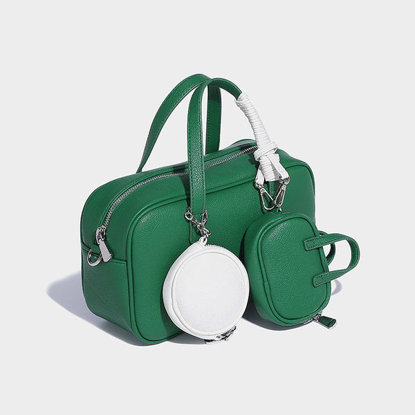 Structured pebbled leather-look Boston bowling bag in tan with blue detachable round mini pouch, dual top handles, and