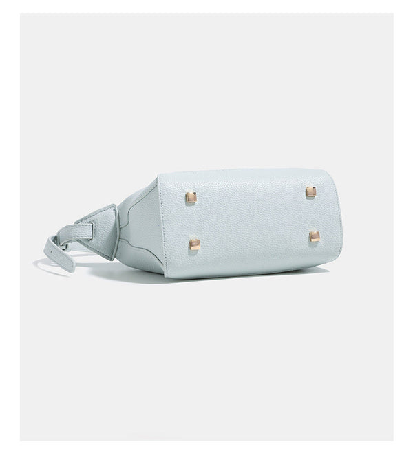 Small structured mini crossbody shoulder bag with pebbled texture, knotted adjustable strap, top zip closure, and gold-tone