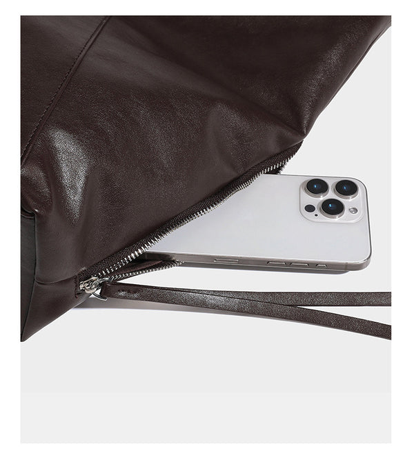 Large slouchy hobo shoulder bag with braided top handle, smooth glossy leather-look finish, and silver-tone ring hardware