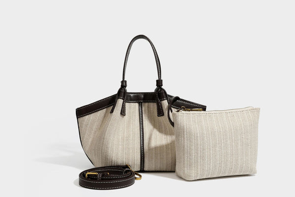 Cremefarbene geflochtene Tote-Bag mit dunkelbraunen Besätzen in Lederoptik, kontrastierenden weißen Nähten, zwei oberen Henkeln und abnehmbarem Schulter