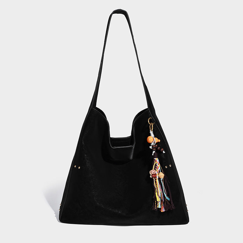 Oversized trapezoid tote bag with matte leather-look finish, gold-tone rivets, and long shoulder strap, detail view 6