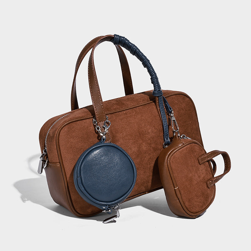 Strukturierte Boston-Tasche im Bowling-Stil in Veloursleder-Optik und Dunkelbraun mit Tragegriffen in Blau und abnehmbarer runder Mini-Tasche, Detailaufnahme