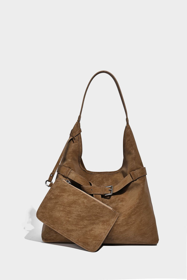 Slouchy oversized shoulder tote bag with matte textured finish, wrap-around buckle strap, and detachable front zip pouch