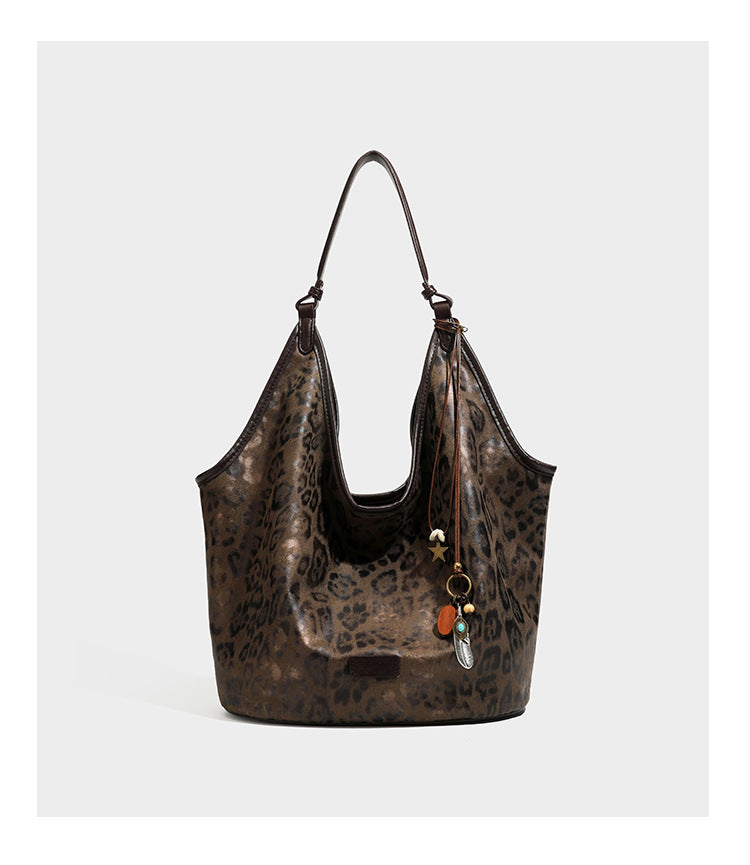 Large slouchy leopard-print shoulder tote bag with glossy tan-and-brown finish, dark brown leather-look trim, single