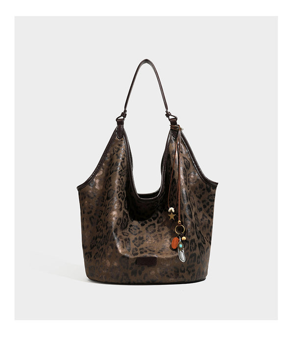 Large slouchy leopard-print shoulder tote bag with glossy tan-and-brown finish, dark brown leather-look trim, single