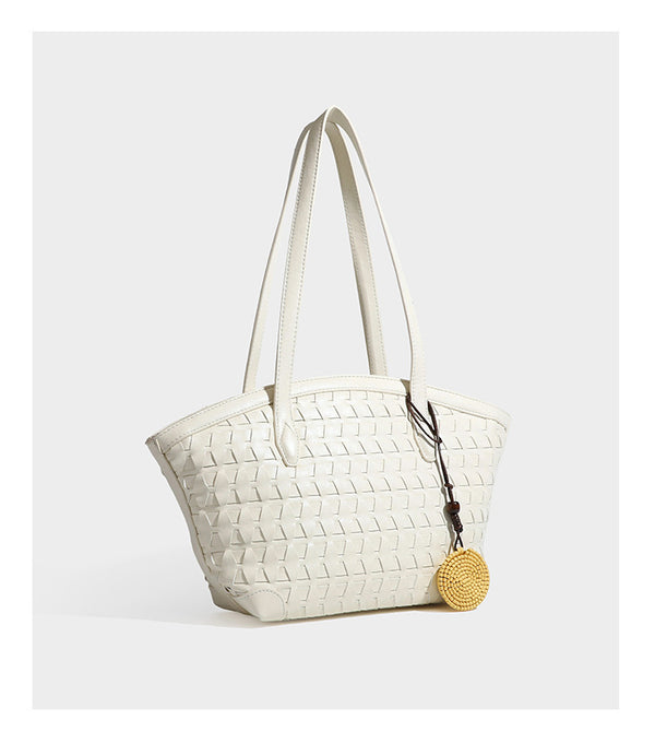Large leather-look tote bag with geometric woven emboss, double shoulder straps, and round woven cord charm in brown, detail