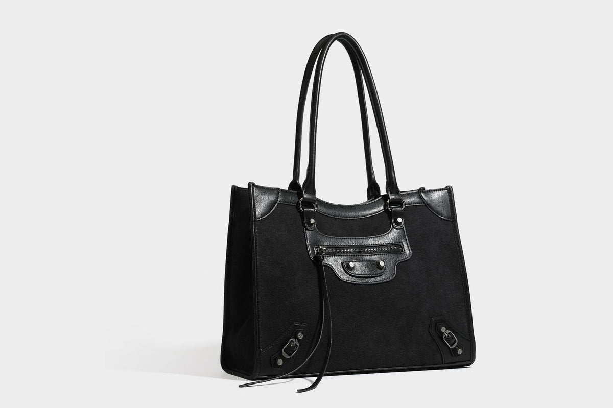 Large structured tote bag with matte suede-like body, smooth leather-look trim, front zip pocket, stud hardware, and