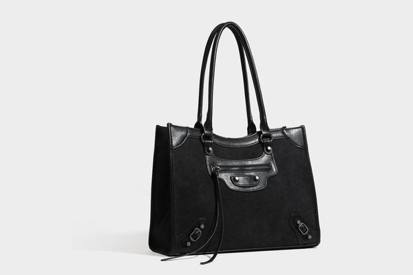 Large structured tote bag with matte suede-like body, smooth leather-look trim, front zip pocket, stud hardware, and