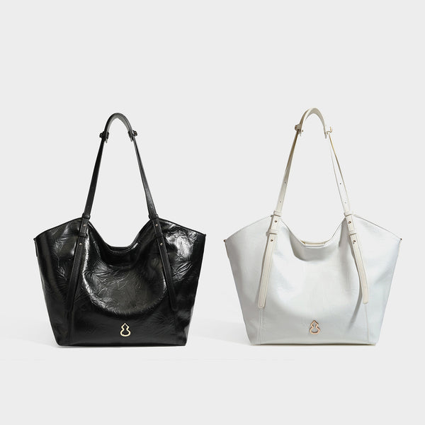 Große, glänzende Tote-Bag in geknitterter schwarzer Lederoptik mit lässiger Trapezform, zwei Schulterriemen und goldfarbenem