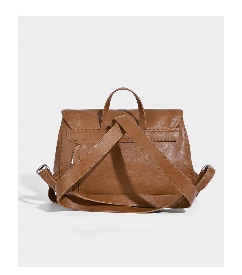 Structured tan leather-look flap backpack handbag with top handle, silver buckle hardware, and fold-over front closure