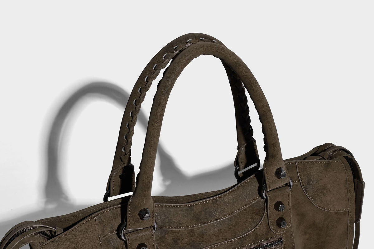 Strukturierte Henkeltasche in matter Velourslederoptik mit geflochtenen Tragegriffen, dunklen Nietenbeschlägen, vorderer Reißverschlusstasche und abnehmbarem