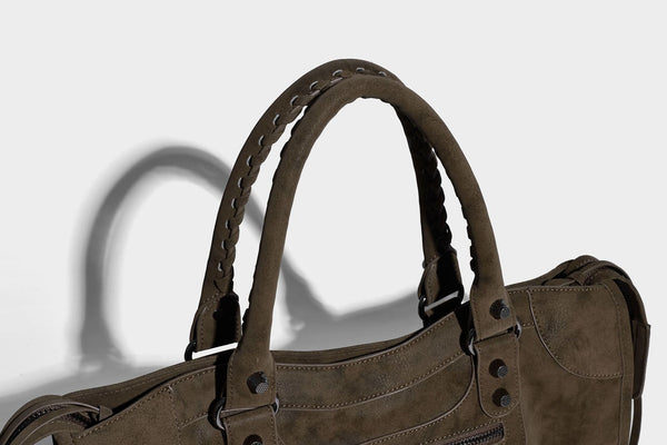 Strukturierte Henkeltasche in matter Velourslederoptik mit geflochtenen Tragegriffen, dunklen Nietenbeschlägen, vorderer Reißverschlusstasche und abnehmbarem
