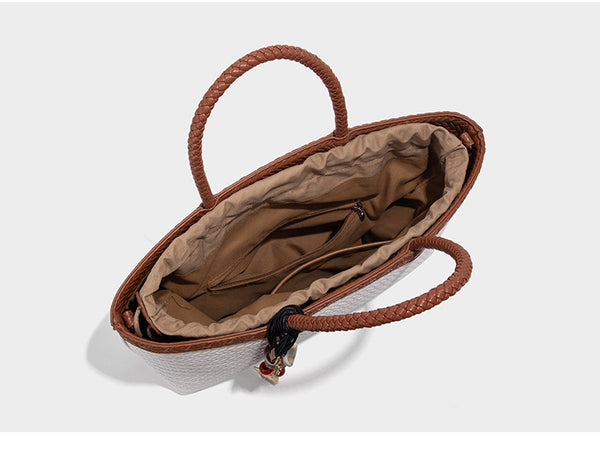 Structured woven-texture tote bag with brown braided top handles, decorative tassel charm, and detachable shoulder strap