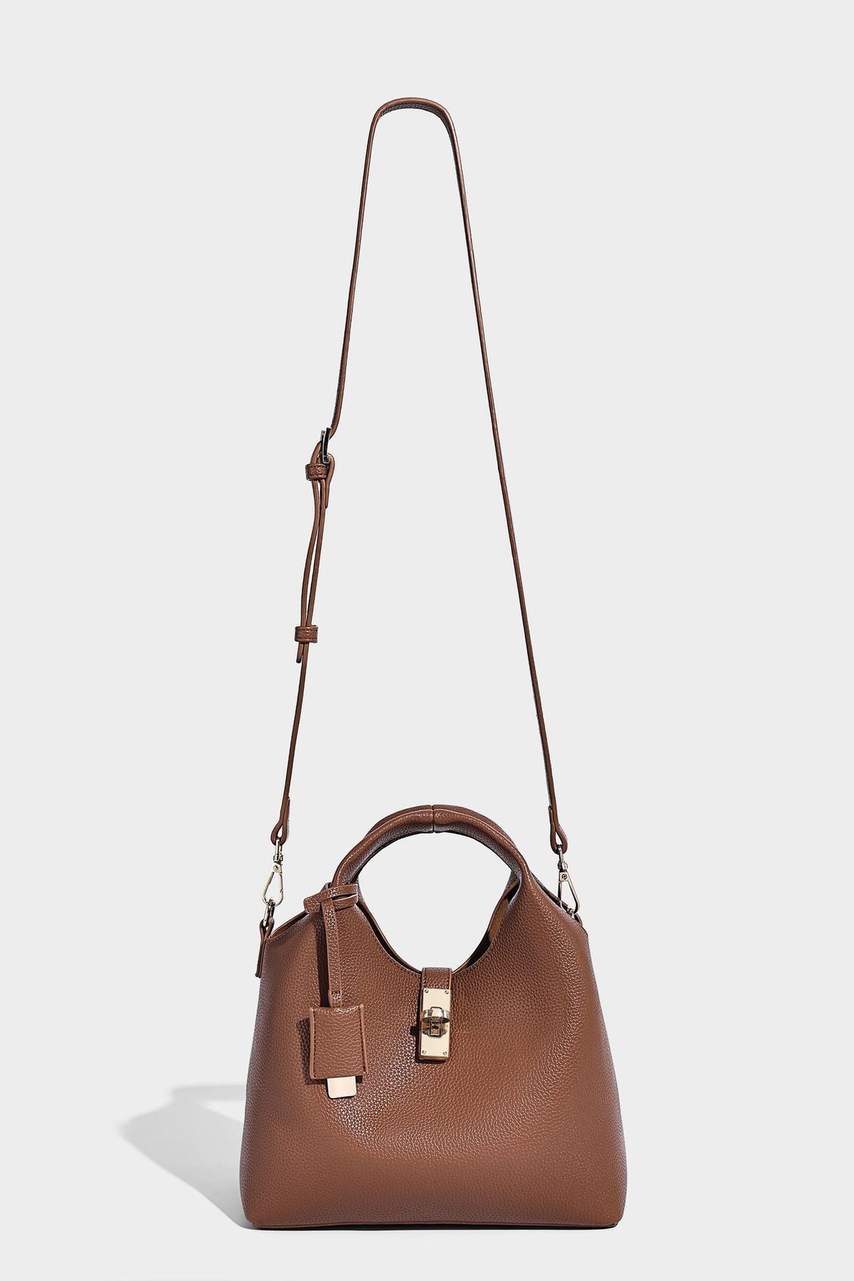 Structured pebbled-texture bucket bag with arched top handles, gold-tone turn-lock closure, and detachable shoulder strap