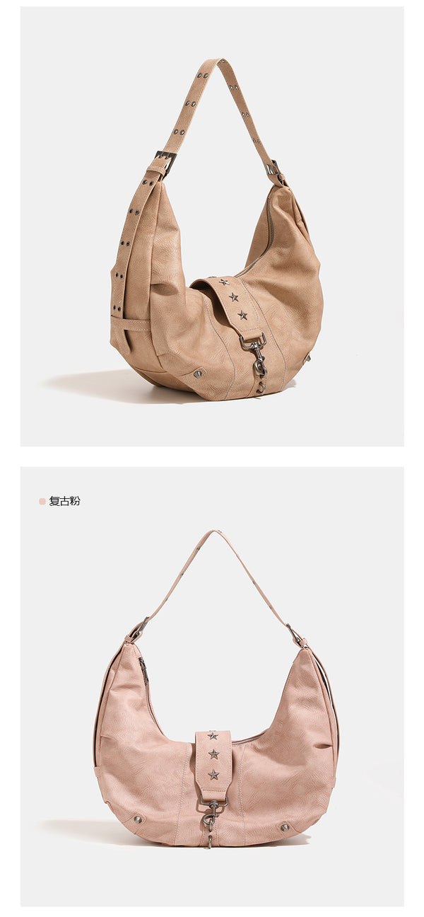 Crescent hobo shoulder bag in matte leather-look finish with star stud front panel, antique-silver hook hardware, and, detail