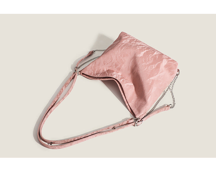Blush pink slouchy hobo bag with crinkled sheen finish, silver-tone chain hardware, and adjustable shoulder strap, detail
