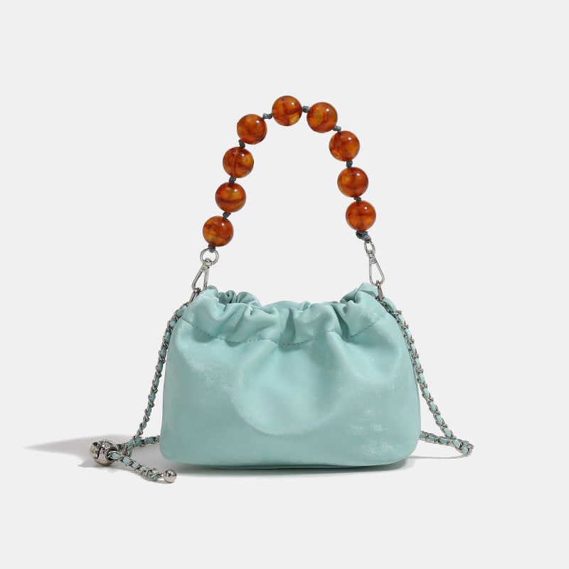 Ruched drawstring bucket bag with amber resin bead handle and silver-tone chain strap, detail view 6
