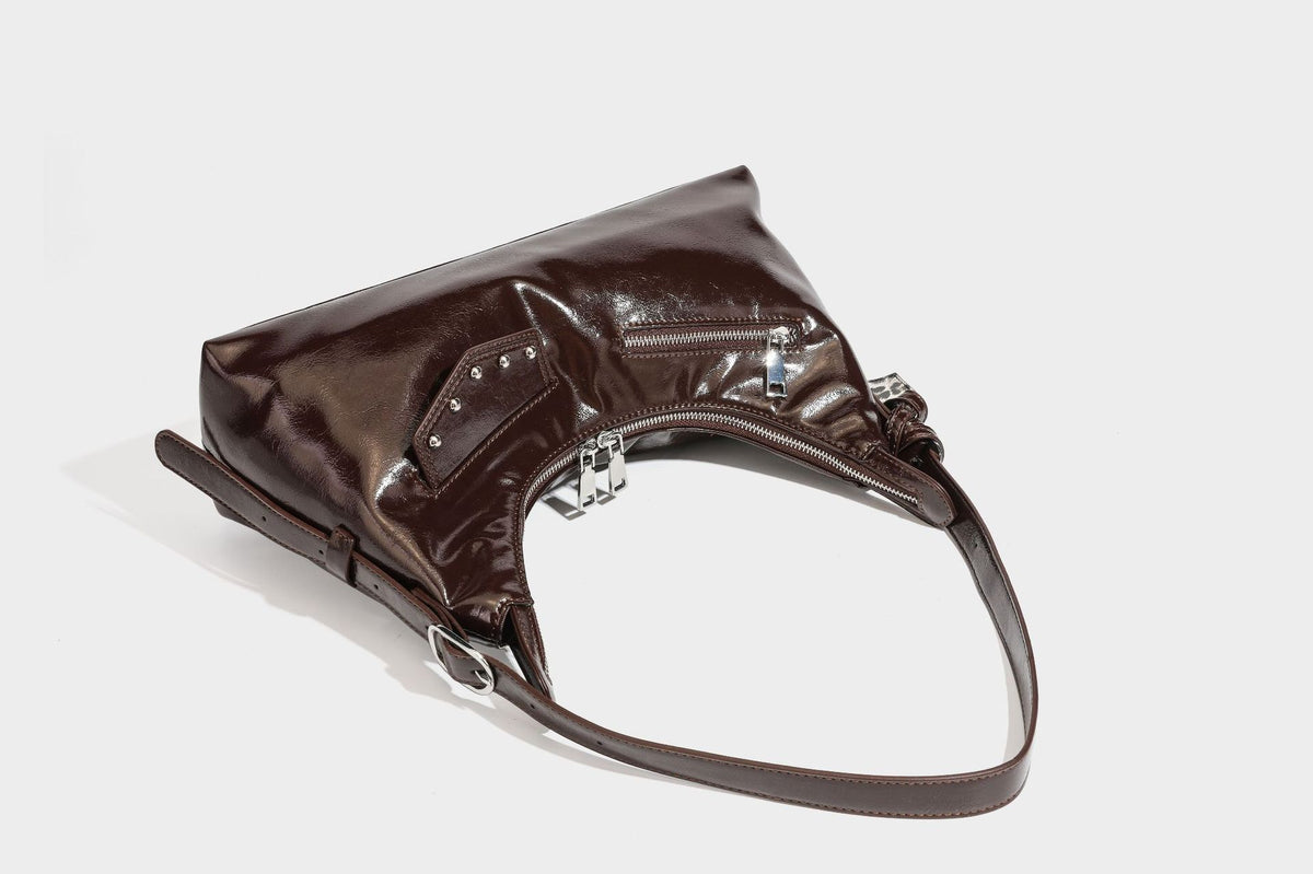 Glossy dark brown hobo shoulder bag with slim strap, front zip pocket, stud detail, and detachable leopard-print heart charm