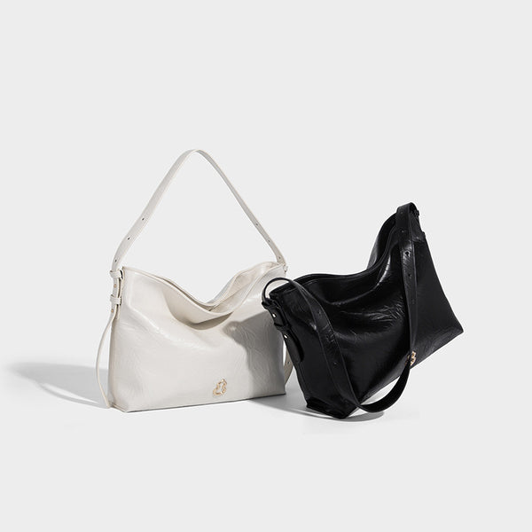Large slouchy hobo shoulder bag in glossy crinkle leather-look finish with gold-tone emblem hardware and adjustable strap