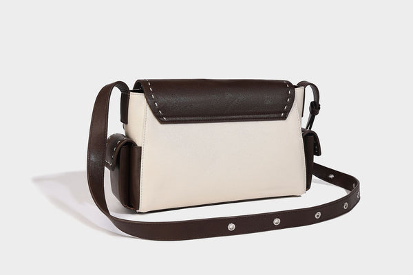 Structured flap crossbody bag in dark brown and cream color-block with white contrast stitching, adjustable shoulder strap