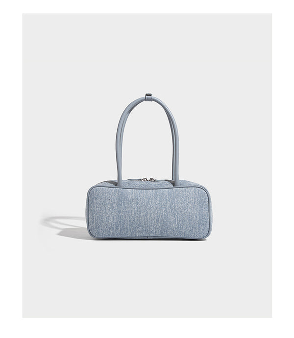 Small structured light blue denim-texture bowling bag with white floral bead embroidery, dual rounded top handles, and