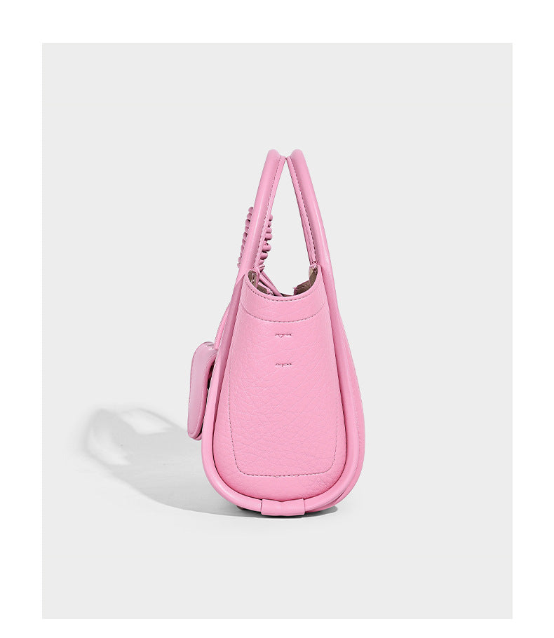 Structured mini tote bag in pebbled leather-look finish with knotted top handles, front flap pocket, and detachable shoulder