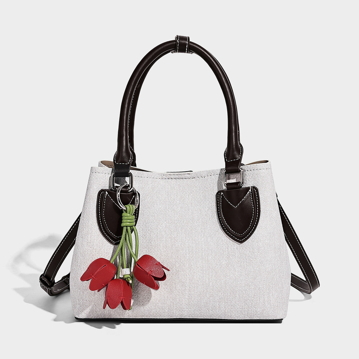 Structured light-blue denim-look tote bag with black leather-look handles, white contrast stitching, silver-tone hardware