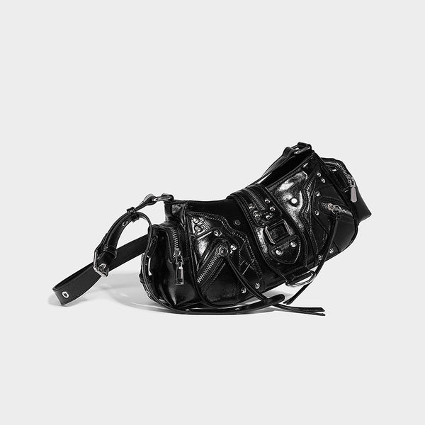 Compact glossy leather-look crossbody bag with silver studs, buckle hardware, and multiple zip pockets, front view