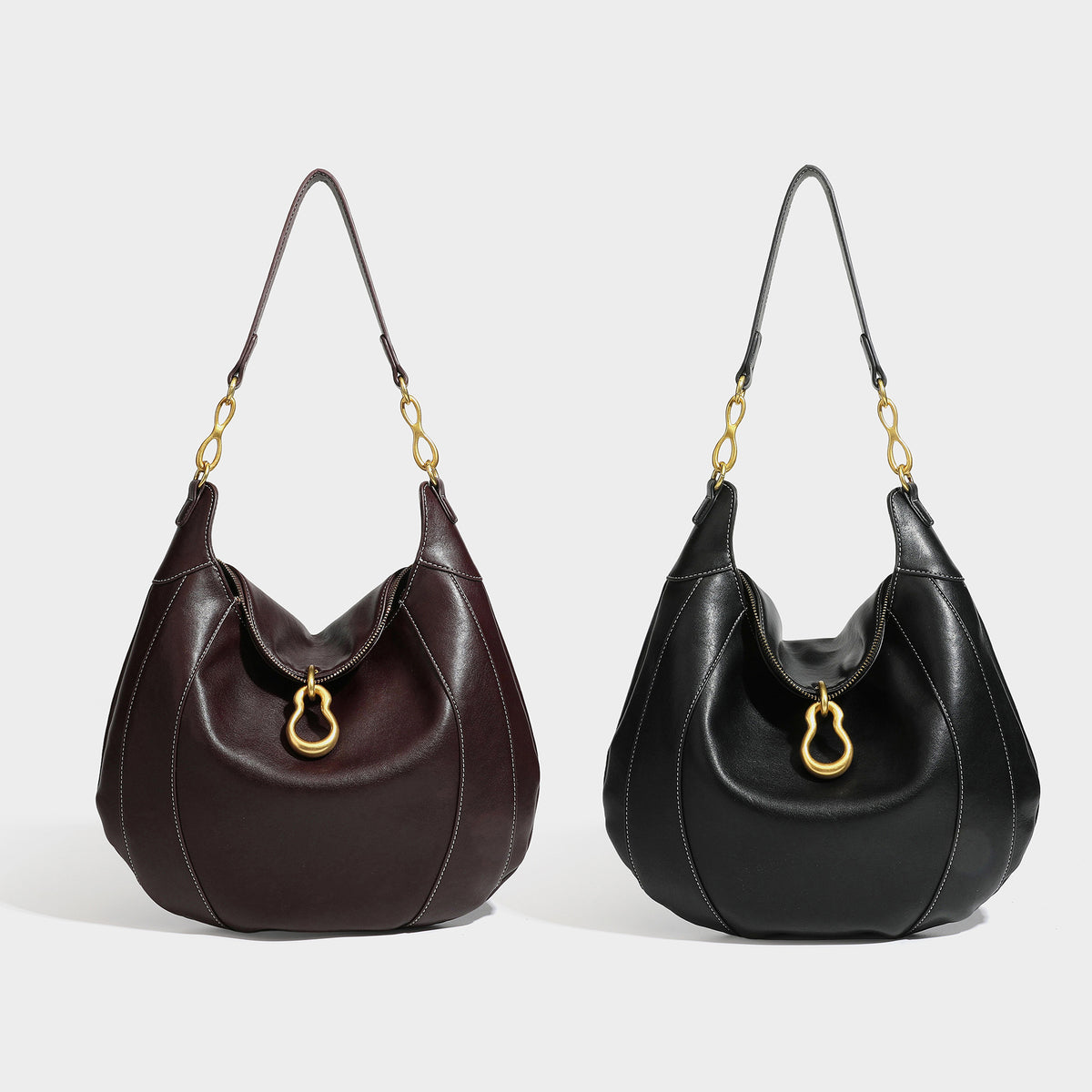 Lässig fallende sichelförmige Hobo-Schultertasche in Dunkelbraun mit goldfarbenem Ring und Kettenglied-Beschlägen sowie Reißverschluss oben, Detailansicht