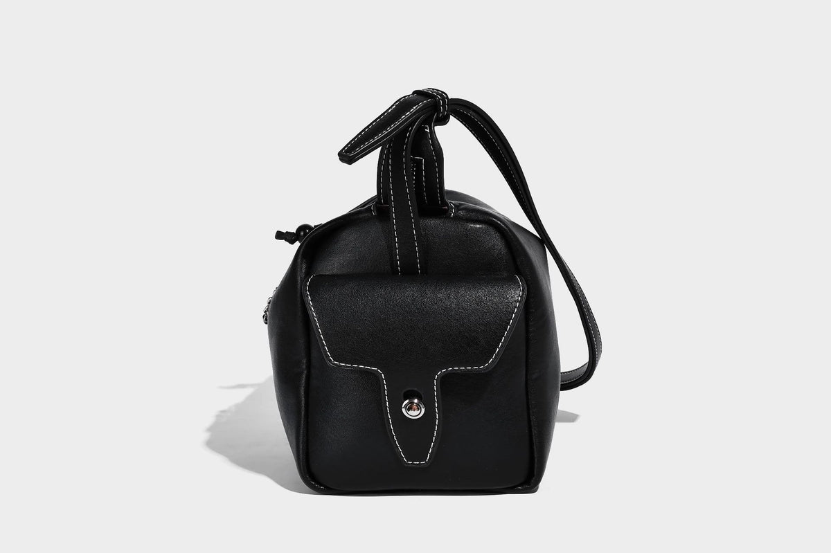 Small slouchy moto-style crossbody bag in smooth matte leather-look finish with white contrast stitching, silver-tone, detail