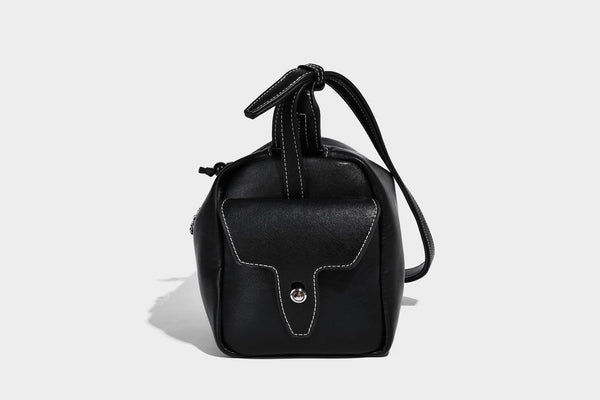 Small slouchy moto-style crossbody bag in smooth matte leather-look finish with white contrast stitching, silver-tone, detail