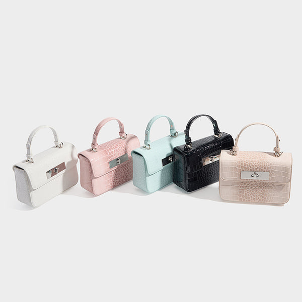 Small structured rectangular satchel with glossy crocodile-embossed finish, arched top handle, front flap, and silver-tone