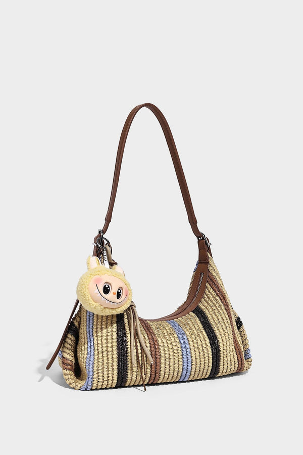 Slouchy woven straw hobo shoulder bag with beige, black, brown, and blue vertical stripes and brown leather-look trim, detail