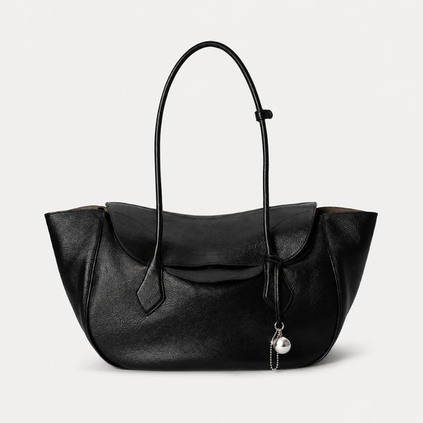 Large winged leather-look tote bag with single arched handle, stitched flap-front panel, and silver ball charm in cognac