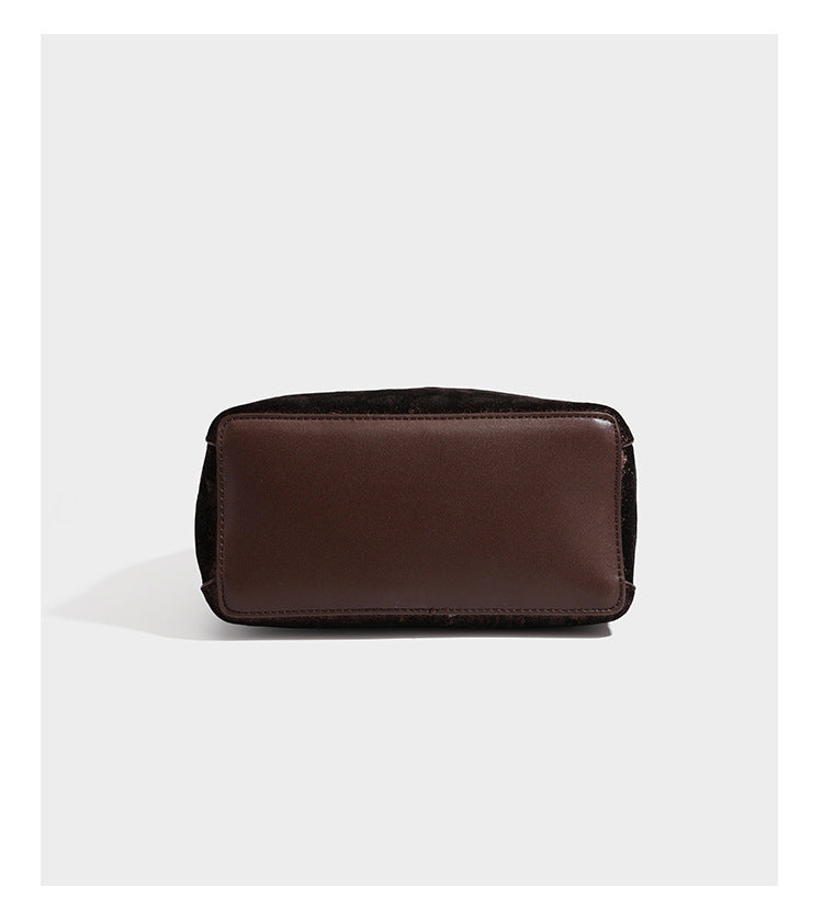 Small structured bucket satchel in embossed velvet-texture fabric with silver turn-lock hardware, rounded top handle, and