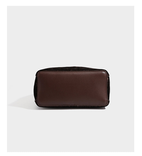 Small structured bucket satchel in embossed velvet-texture fabric with silver turn-lock hardware, rounded top handle, and