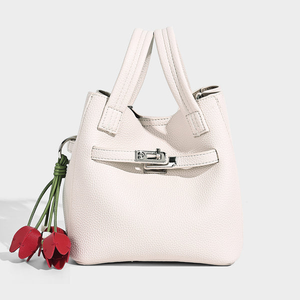 Small structured pebbled bucket tote bag with dual top handles, silver turn-lock front pocket, and detachable shoulder strap