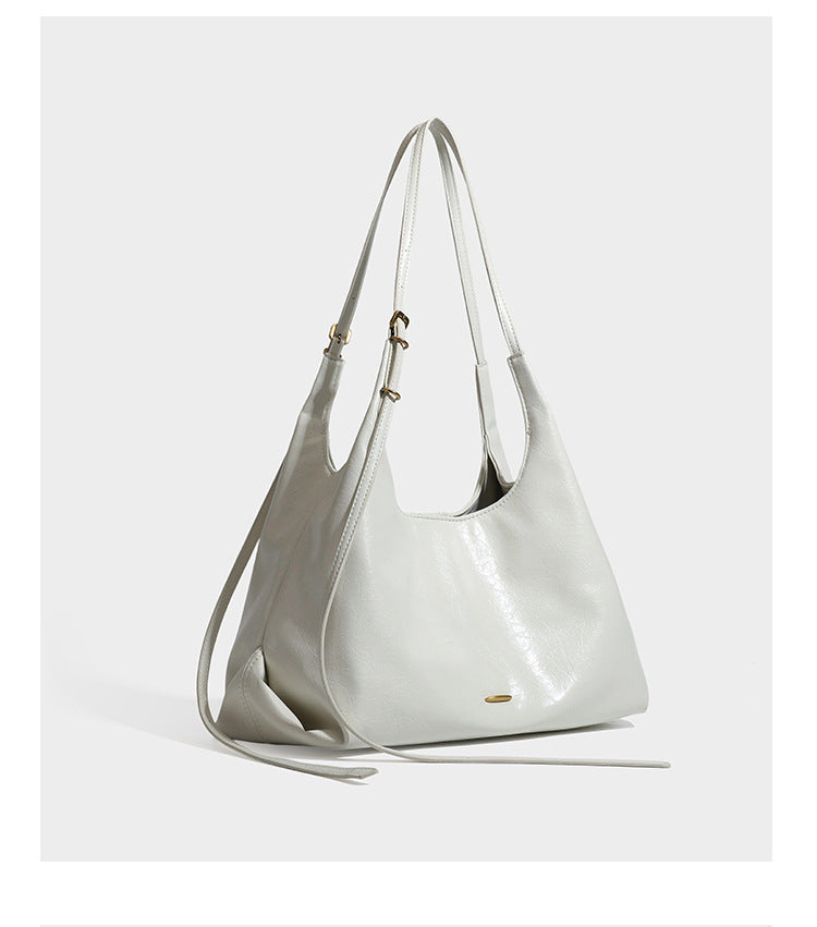 Lässige Hobo-Schultertasche mit offenem Oberteil in glänzender, geknautschter dunkelbrauner Lederoptik mit schmalem verstellbarem Riemen und goldfarbenem
