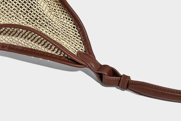 Two-tone beige and cream woven straw hobo shoulder bag with brown leather-look trim, long shoulder strap, and tassel-bead