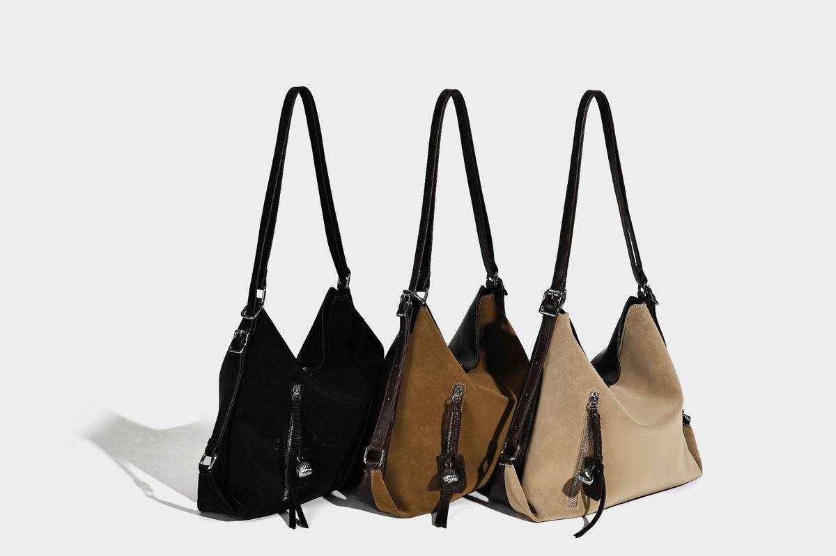 Slouchy hobo tote bag with matte leather-look finish, triangular silhouette, front zip pocket, and adjustable shoulder strap